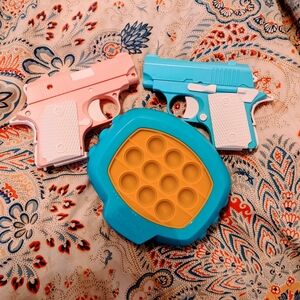 Set of 2 toy guns and "popit!!" Game.